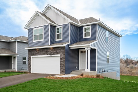 A two-story house with a garage on the first floor and a front porch on the second.